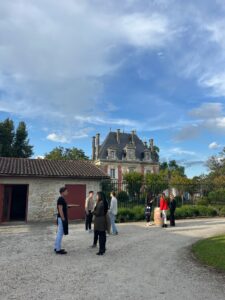 Invités échangeant dans la cour d’un domaine bordelais lors d’un cocktail organisé par le Groupe Optilia et Bouger à Bordeaux